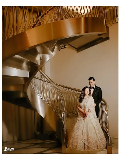 Isht and Paavni posing on a grand spiral staircase in Dubai, a perfect example of a glamorous destination wedding portrait.