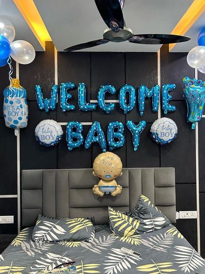A close-up of the 'Welcome Baby Boy' wall decor, with foil letters and character balloons.