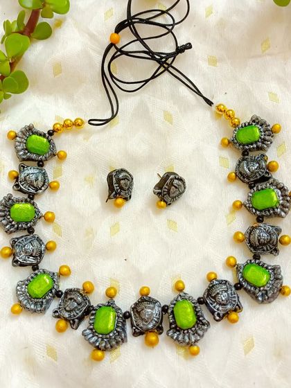 A duplicate image showing the detail of the Durga motif choker necklace. The oxidized silver finish on the faces contrasts beautifully with the vibrant green beads.