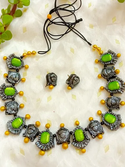 A duplicate image showing the detail of the Durga motif choker necklace. The oxidized silver finish on the faces contrasts beautifully with the vibrant green beads.