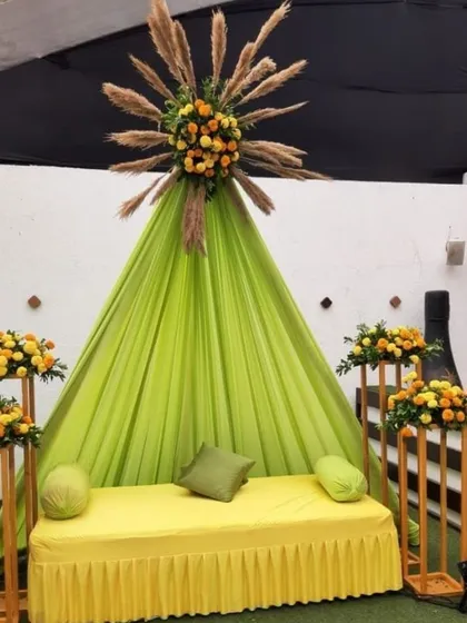 A unique Haldi seating idea with a lime green tent-style backdrop and pampas grass accents. This modern take on Haldi decor is perfect for a chic celebration.