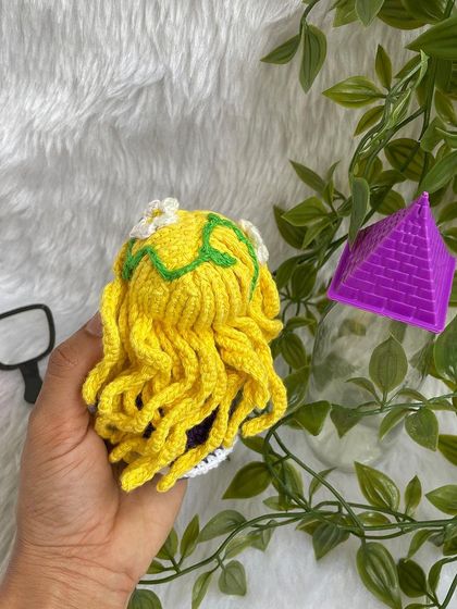 Disney Princess Rapunzel, with her long, flowing yellow hair decorated with flowers. Her purple dress is detailed with corset lacing, just like in the movie Tangled.