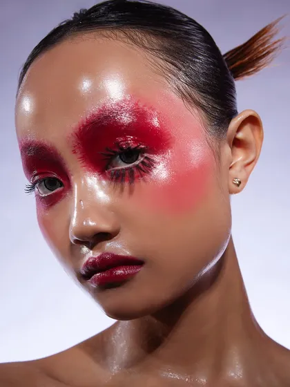 A student's beautifully executed glass skin concept shoot. This look features a glossy red blush and eye combination, showcasing an advanced and trendy technique.