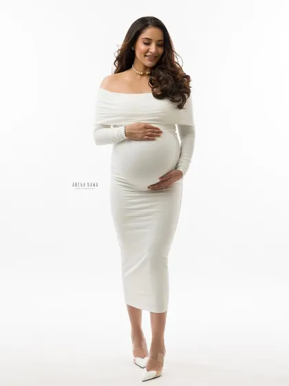 A full-length portrait in a classic white gown. This timeless look is always in style and creates a feeling of purity and elegance for your maternity photos.
