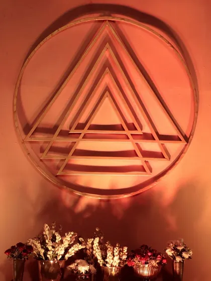 A close-up of the geometric Shri Yantra symbol, crafted as a key decor element. The warm, ambient lighting highlights its form, representing the union of masculine and feminine energies.