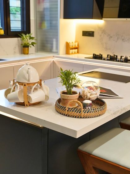 A close-up of the island countertop, a perfect spot for a morning cup of tea. The details, from the plant to the tea set, show how a kitchen becomes a home.