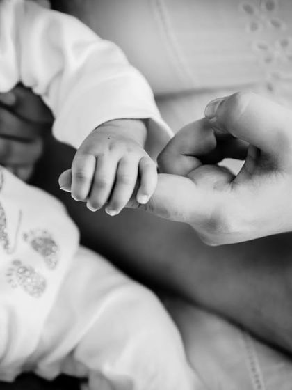 A newborn's tiny hand grasping a parent's finger. This black and white detail shot is incredibly powerful and emotional.