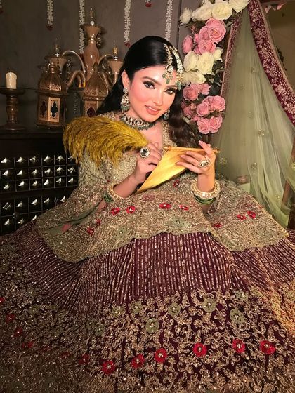 This look is inspired by Mughal royalty, with the model holding a scroll. The makeup is flawless and majestic, fitting for a queenly portrait.