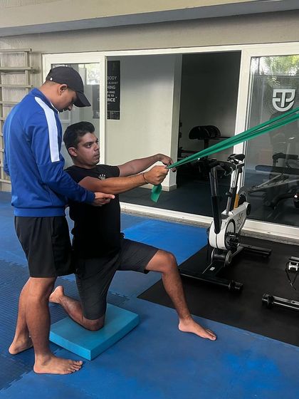 An athlete performs a core and rotational strength exercise with a resistance band. This type of training is essential for developing power and stability in the golf swing.