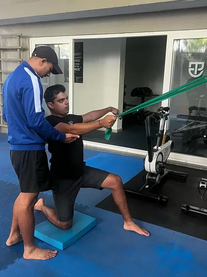 An athlete performs a core and rotational strength exercise with a resistance band. This type of training is essential for developing power and stability in the golf swing.