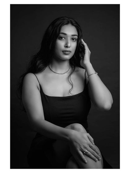 A quiet and thoughtful black and white portrait. The model's pose and expression convey a sense of introspection and peace.
