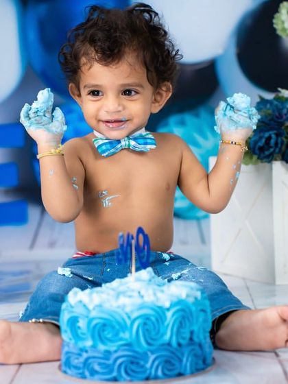 Hands full of cake and a heart full of joy. This little one is celebrating his first birthday with a classic blue and white themed cake smash.