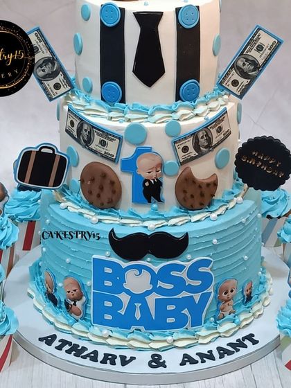 The bottom tier and cupcakes of the Boss Baby twins' celebration. The main cake features a large "Boss Baby" logo and the twins' names, Atharv & Anant.