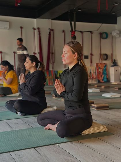 A moment of shared stillness and intention at the start of class. Yoga unites body, mind, and soul, and practicing in a group amplifies this sense of connection and inner peace.