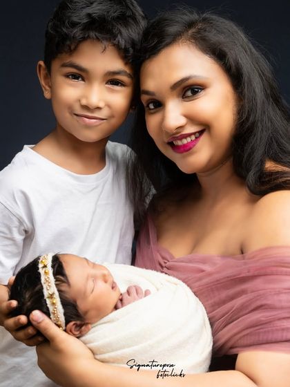 A mother and son share a loving look with their newborn baby girl, a precious moment from an on-location family shoot.
