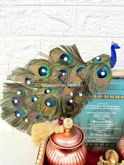 The stunning peacock feather arrangement on our wedding invitation hamper. It adds a touch of royalty and grace to this very special announcement.