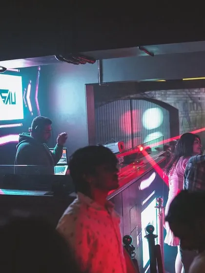 A shot from the side of the club, showing my presence in the DJ booth with the 'SAU' logo visible to everyone. The red laser lights add to the intense club atmosphere.