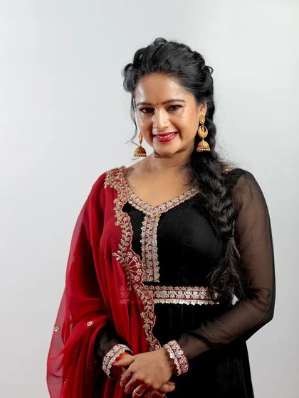 Actress Duniya Rashmi at the Chittara Star Awards. This portrait highlights her beautiful black and red outfit and her warm, engaging smile.