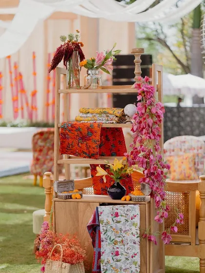 A detail shot of a wooden shelf decorated with printed fabrics and bougainvillea for the 'Rajasthani Folklore' Mehendi.
