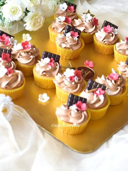 This angle highlights the piped frosting and the small floral decorations on the cupcakes.