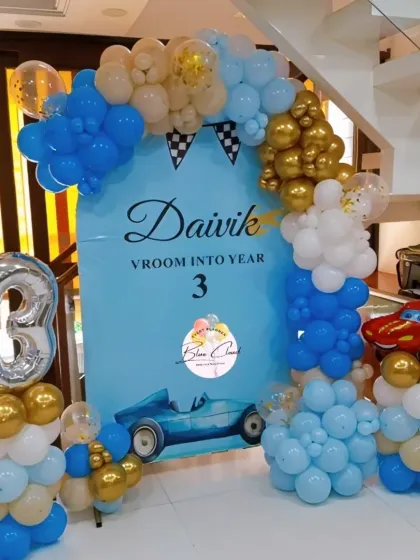 A 'Vroom into Year 3' car-themed birthday setup with a custom backdrop, balloon garland, and a number '3' foil balloon.