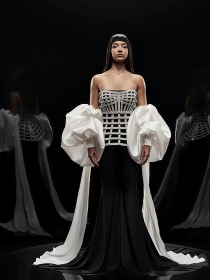 A full-length shot of a black body-con jumpsuit by Alpana Neeraj, with dramatic sleeves and a woven corset.
