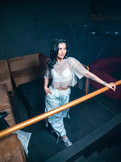 Another shot from the pre-gig photoshoot, showing off my full outfit. The mesh top and patterned pants are a favorite combo.