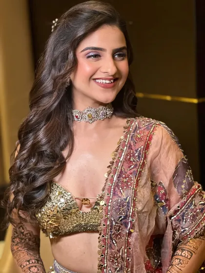 A beautiful smile from our Mehendi bride. The soft lilac shimmer on her eyes complements the intricate work on her outfit, creating a look that is both modern and glamorous.