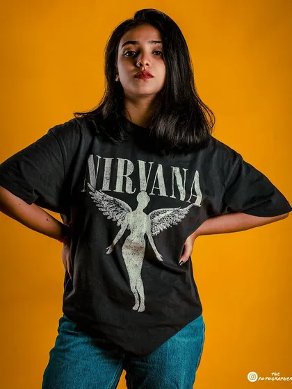 A three-quarter shot from the yellow background series, showing more of the casual styling and confident pose.