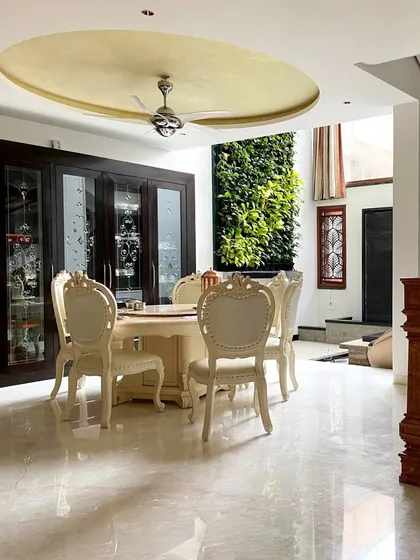 We brought the outdoors in by incorporating a lush vertical garden next to the dining area in this Bengaluru residence. This biophilic design element provides a refreshing natural view, perfectly complementing the elegant, classic furniture and polished marble floors.