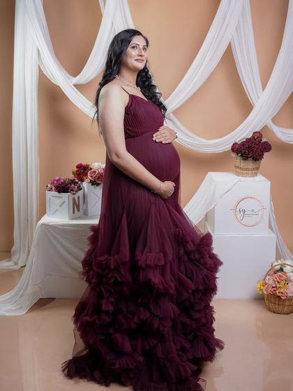 A stunning full-length portrait in a dramatic maroon ruffled gown. The elegant draping and rich color make this a truly standout shot.