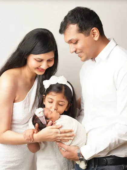 The whole family together, with the big sister giving her new baby sibling a kiss. This is the kind of heartwarming family portrait that will be treasured for a lifetime.
