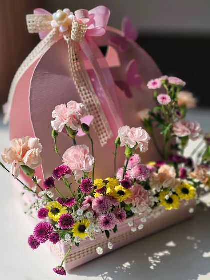 The perfect blend of form and function. This pink floral caddy is not only a beautiful way to present a gift but also a lovely keepsake for the new parents to use in the nursery.