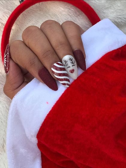 Another view of the Christmas-themed press-on nails, showing the cute reindeer and candy cane stripe designs. Perfect for an instant holiday manicure.
