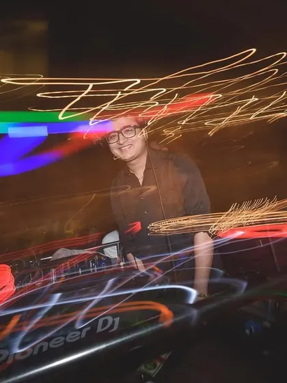 Surrounded by streaks of light, this long-exposure shot turns the DJ booth into a canvas of energy.