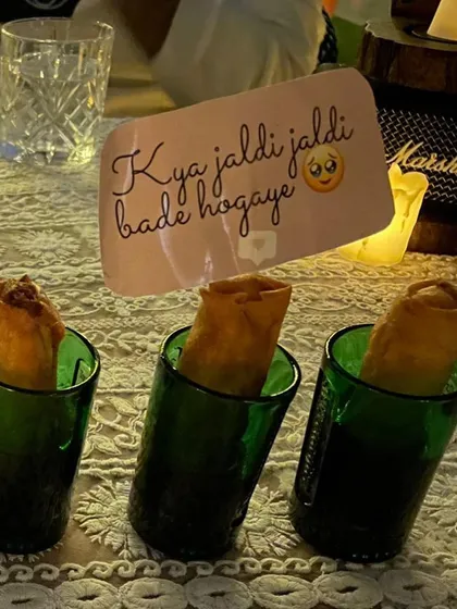 Another playful detail from a bridal shower. Crispy spring rolls are served in individual glasses, each with a custom tag that adds a personal and humorous touch to the celebration.