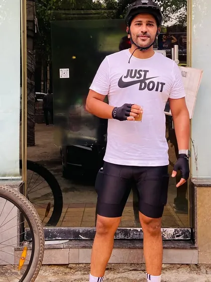 A member in a "Just Do It" shirt, holding a cup of tea. That's our philosophy: work hard, then relax and enjoy.