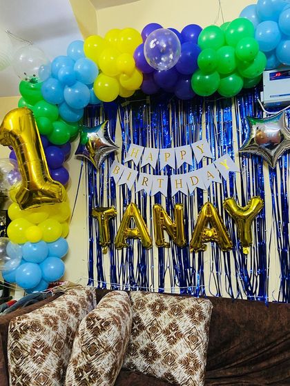 This shot captures the side of the balloon arch, showing the mix of blue, green, and yellow balloons.