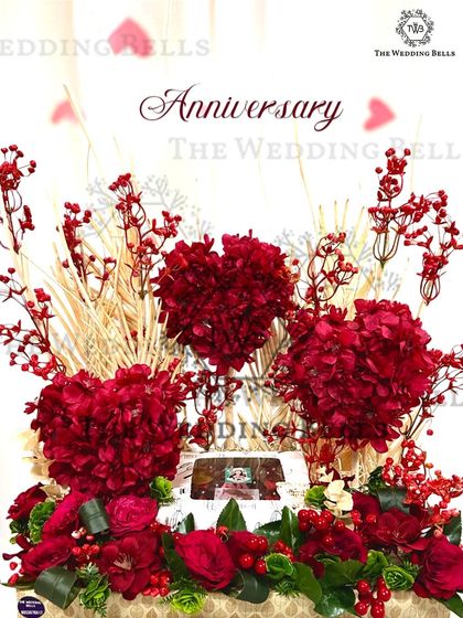 A love that blooms deserves a grand gesture. This anniversary hamper features a stunning arrangement of red flowers, including heart-shaped bouquets, to celebrate everlasting love.