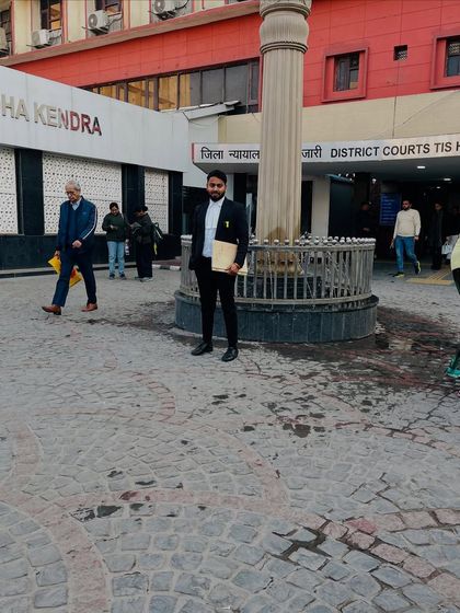 A moment outside the Tis Hazari District Courts, holding a case file and ready for the day's proceedings.