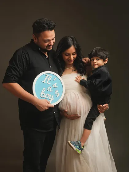 It's a boy! This family shares their happy news during their maternity session, with their son looking on. It's a wonderful way to include the whole family in the excitement and anticipation.