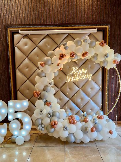 A different view of the elegant 25th anniversary decor. The soft lighting on the balloon arch and marquee numbers creates a warm and celebratory atmosphere, highlighting the milestone in a sophisticated way.