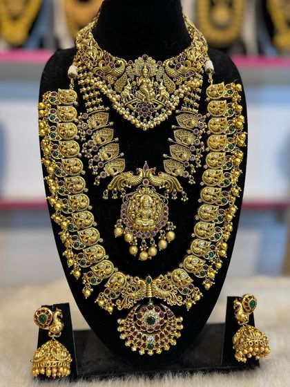 A beautiful temple jewellery set with peacock and Lakshmi motifs. The combination of choker, mid-length necklace, and haram creates a stunning layered effect.