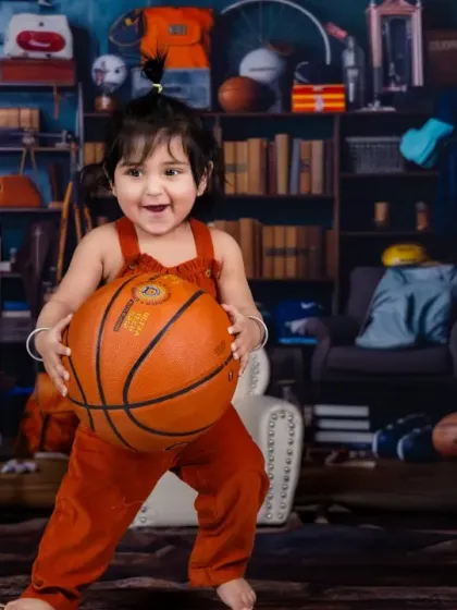 Having a ball. This little athlete is surrounded by sports equipment in our playful "play time" themed room.