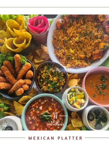 A complete Mexican Platter featuring spicy rice, paneer tikka, nachos, various dips, and fresh salads. It's a hearty and flavorful spread that brings the taste of Mexico to your party.