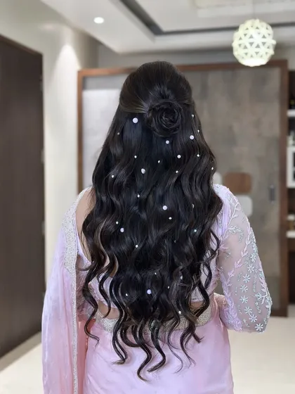 A beautiful half-up style with a rose bun and scattered pearls. This hairstyle is dreamy, romantic, and perfect for a soft, feminine look.