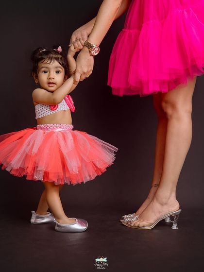 A creative shot focusing on the little ballerina holding her mom's hand. This highlights the contrast in size and the supportive bond between them.