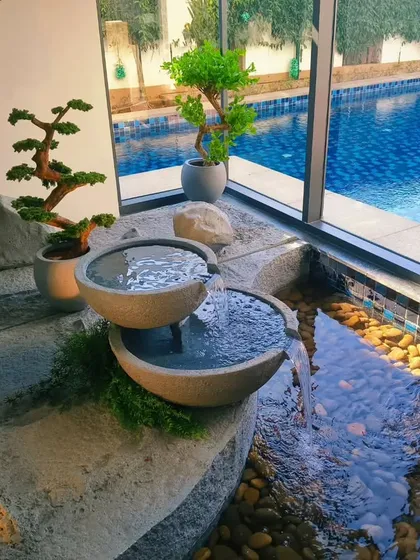 A closer look at the details of our indoor Zen fountain. We meticulously select and place each element, from the hand-finished stone bowls and natural river pebbles to the carefully chosen bonsai and bamboo plants, ensuring the feature integrates perfectly with your home's aesthetic.