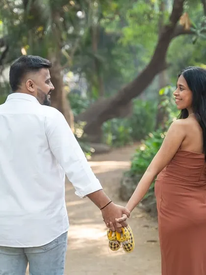 A quiet walk together, holding hands and a tiny pair of shoes. This shot from behind captures the couple's journey forward into parenthood.
