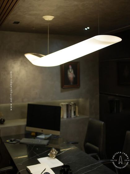 A duplicate of image 118, this shot from a different angle highlights the fixture's slender profile and how it appears to float above the desk.